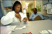 Nurse Scherri Rucker-Graves sets up an HIV test in the exam room of
the Atlantic City Health Department's mobile van in Atlantic City,
N.J., in this June 16 file photo. Two large studies find that
testing all adults once, and testing people in major cities or
high-risk groups every three to five years, would be a
cost-effective way to reduce new HIV infections by about 20 percent
each year and get patients needed help.