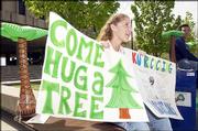 Kansas University students Amy Applebaum, left, and Christopher
Nguyen encourage students to "hug a tree" during Earth Day in 2002.