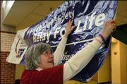 Cancer survivor and team captain for this year&squot;s "Relay for Life"
Dianne Nelson helps hang a welcome sign at Free State High School.
Organizers and volunteers for the fund-raiser for the American
Cancer Society gathered Tuesday at the school to kick off the
event.