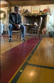 Pieces of an old basketball court from Allen Fieldhouse make up the
first floor of a rural Douglas County home. The house, an 1870s
Pennsylvania Dutch barn, is now for sale, and Craig Brown, a
Realtor with Realty Executives, above, shows the house, and also
helped install the floor with his father, Bob Brown, a 1951 KU
engineering graduate, who used to live in the house.