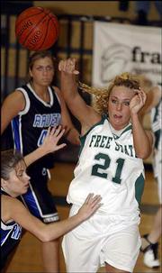 Free State High's Jamie Stanclift (21) dishes to a teammate. FSHS
beat Olathe Northwest, 45-31, Friday night at Free State.