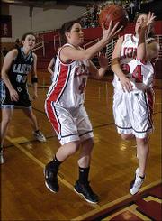 Lawrence High's Kayla Nolte (4) tries to save a loose ball from
going out of bounds against Shawnee Mission East as teammate Lacey
Elmore (24) tries to get out of the way. The Lions lost to the
Lancers, 57-42, Friday at LHS.