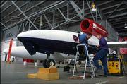 Philip Grassa, crew chief for the GlobalFlyer, exits the plane
after completing repairs while another crew member prepares to make
more modifications. The plane is tentatively scheduled to take off
from Salina Municipal Airport this week in an attempt to make
history by flying solo nonstop around the world without refueling.