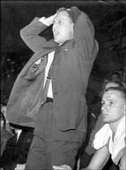 KU coach Dick Harp rises from the bench. During a game in 1958,
Harp implored KU fans to stop booing Missouri's Mike Kirksey.