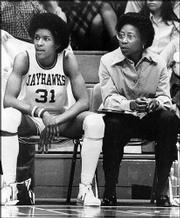 Kansas standout Lynette Woodard, left, and then-coach Marian
Washington sit on the KU bench. Woodard holds the women's record
for points scored in a fieldhouse game -- 44.