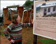Michelle Dalva, director of Habitat for Humanity's Global Village
in Americus, Ga., looks over a sign announcing a Sri Lankan home
under construction Monday. Habitat plans to build 25,000 houses,
some similar to the one pictured, for victims of the Indian Ocean
tsunami. The group will focus on hard-hit Sri Lanka, Thailand,
Indonesia and India.