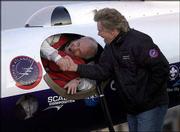 Pilot Steve Fossett shakes hands with Sir Richard Branson as he
prepares to take off in the GlobalFlyer at the Salina Municipal
Airport. Fossett embarked Monday on an attempt to fly the
GlobalFlyer around the world nonstop without refueling. Branson,
head of Virgin Atlantic, is financing the mission.