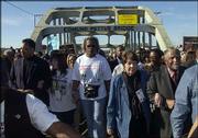 The Rev. Jessie Jackson, far left, walks with marchers Sunday on
the Edmund Pettus Bridge in Selma, Ala.. At far right are the Rev.
Joseph Lowery and his wife, Evelyn Lowery. Joseph Lowery joined the
Rev. Martin Luther King Jr. on the march 40 years ago.
