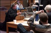 Douglas County District judge Robert Fairchild, left, works to fix
some computer projection equipment before closing arguments in his
courtroom in the murder trial of Tom E. Murray. Murray, a Kansas
State University professor, pictured in foreground at right, is
charged with murdering his ex-wife, Carmin D. Ross, in November
2003 at her home northwest of Lawrence.
