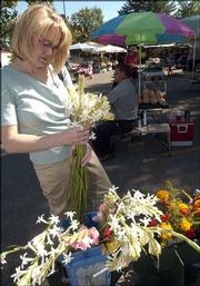 Lora Stoppel, Lawrence, picks out some tuberosas to buy last summer
at the Lawrence Farmers Market. A workshop for new and veteran
vendors at the market is planned for Saturday at the Douglas County
Fairgrounds.