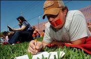 Luke Underberg, 25, of Overland Park, a member of The Cause USA,
wears tape on his mouth while reading from scriptures in front of
the Woodside Hospice in Pinellas Park, Fla., where Terri Schiavo
was spending her second day without a feeding tube.