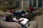 Clockwise from front, Trena Anderson, director of basketball
operations; Katie O'Connor, assistant coach; Kyra Elzy, assistant
coach; husband of assistant coach Karen Lange; Karen Lange; and
head coach Bonnie Henrickson break down film of a 62-45 loss to
Minnesota. The staff regularly meets at Henrickon's Lawrence home
after games to critique the team's play.