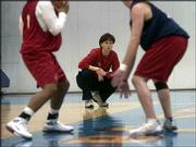 First-year Kansas University women's basketball coach Bonnie
Henrickson is framed between a pair of Jayhawks in this file photo
from Dec. 4. Henrickson coached KU to a 12-16 record this past
season.