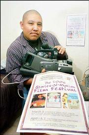 Thomas Yeahpau, a Haskell Indian Nations University student, shows
a poster for the upcoming American Indian film festival at Haskell,
at which he and other Haskell students, as well as a former "NYPD
Blue" star, will show their work.