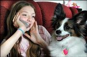 Patty Wiegner sits with her dog Bingo at her Valrico, Fla., home
talking with a friend. Patty, 11, wanted just two things for
Christmas -- a cellular phone and a dog. She got both of her
wishes.