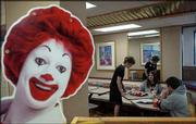Harlanne Roberts, a reading teacher at South Junior High School,
cleans off a table at McDonald's, 901 W. 23rd St., where SJHS
students Alyssa Myers and Adrian Peña eat dinner. Teachers from the
Lawrence school district worked at three restaurants Tuesday for
McTeacher's Night, and McDonald's donated 20 percent of the sales
during the four-hour period to the school district.
