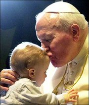 Pope John Paul II kisses an unidentified baby at the end of a
general weekly audience in the Pope Paul VI Hall at the Vatican,
Wednesday, March 14, 2001.