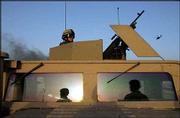 U.S. Army task force 1-41 infantry soldiers take position at the
scene of an attack against an M-1064 armored personnel carrier,
burning in the background, in West Baghdad, Iraq, Friday. A report
commissioned by President Bush, issued Thursday, says that all of
the U.S. claims about weapons of mass destruction in Iraq had been
disproved by U.N. inspectors.