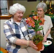 Meadowlark Garden Club members Dorothy Curnes, left, and Virginia
Curran look over an arrangement created by Hy-Vee floral manager
Cindy Goldring. The club heard a presentation from Goldring at its
monthly meeting on Tuesday.
