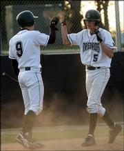 The Firebirds' Jake Hoover (9) congratulates Anthony Dreiling after
Dreiling scored a run in the fourth inning. The Firebirds toppled
the Lions, 8-3, Thursday evening at FSHS.