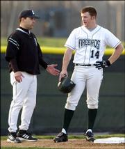 Free State high baseball coach Mike Hill, left, chats with Firebird
base runner Brett Lisher. The Firebirds beat Lawrence High, 8-3,
Thursday night at Free State Field.