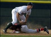 Free State High third baseman Cory Cooper attempts to tag out
Lawrence High base runner Travis Hart.