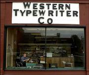 Bill Mark is framed in the window of his Topeka shop as he repairs
a typewriter Tuesday. Mark's fascination with typewriters dates to
his childhood, when he sometimes accompanied his father to the
family business to tinker with old machines from the 1930s.