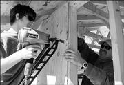 VOLUNTEERS nathan dick, left, and his father, Gary Dick, work on Lawrence Indian Methodist Church, 950 E. 21st St. The renovation should be completed by the end of fall.