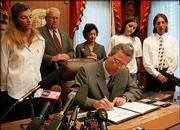 Gov. Jeb Bush, seated, signs into law the Jessica Lunsford Act
during ceremonies Monday in Tallahassee, Fla. The bill enhances
penalties for sexual crimes against children. Family members of
Sarah Lunde and Jessica Lunsford, who were victims of sexual
predators, were present. Standing, from left, are: Kelly May, Sarah
Lunde's mother; Rep. Charlie Dean, R-Inverness; Sen. Nancy
Argenziano, R-Crystal River; Rebekah Lunde, Sarah Lunde's sister;
and Mark Lunsford, father of Jessica Lunsford.