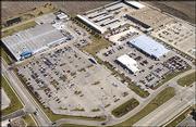 Lawrence city officials issued a building permit for Wal-Mart to
expand its center at 3300 Iowa, pictured in the upper left of this
aerial photo looking southeast from the corner of 33rd and Iowa
streets. Wal-Mart is scheduled to add 94,427 square feet to
accommodate a grocery store, fuel center and drive-through
pharmacy. The space includes land now occupied by Crown Toyota, at
center right of photo, which is moving into the former Payless
Cashways building at top right.