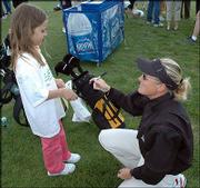 Kelsey Consolver, 9, gets an autograph from Futures Tour player
Cecilie Eckbo, right. Eckbo helped teach a clinic during a break in
practice Wednesday at Eagle Bend.
