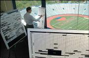 Kansas University is switching to a ticket allocation system that
will give football fans more of a say in where they will sit at
Memorial Stadium. The new system, named Select-A-Seat, will be
tracked on boards like that in the foreground with seats marked off
as reserved by fans. At left is associate athletic director Jim
Marchiony, who says the system could be used for other sports,
including men's and women's basketball.