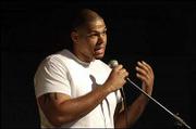 Former Kansas University football player Travis Watkins recites his
poem "Tsunami Economy" during a monthly poetry slam competition.
When he wasn't running the event Saturday at the Hawk's Nest in the
Kansas Union, he recited some of his own works.