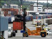 A shipping container is removed from an inbound tractor-trailer
Wednesday in Seattle at the Port of Seattle. The U.S. trade deficit
fell sharply in March to $54.99 billion, the lowest level in six
months, as U.S. exports climbed to an all-time high.