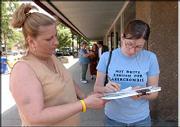 Charlotte Hastings, left, Lawrence, collects Lizz Conley's
signature near Ninth and Massachusetts streets. Hastings and her
mother, Keri Collins, pictured in background at left, solicited
signatures Tuesday from people downtown in an effort to keep
convicted sexual predator Leroy Hendricks and others like him from
moving to town.