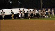 Baseball players from Lawrence High and Free State roll out the
tarp to cover the infield during the fourth inning. The Firebirds
were leading, 5-4, when Thursday night's game at Hoglund Ballpark
was suspended until today because of lightning and rain.