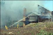 Douglas-County Fire & Medical firefighters work to extinguish a
fire Monday afternoon at a vacant house new Peterson Road and
Monterey Way.