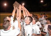 Free State High baseball players hold aloft the Class 6A regional championship trophy after a 14-13, eight-inning victory over Topeka High. Firebird Andy Petz (20) had the game-winning RBI on Thursday at Free State.