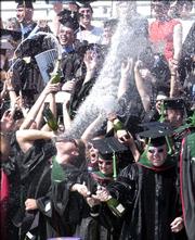 Kansas University medical students celebrate the conferral of their degrees during commencement at Memorial Stadium on Sunday.