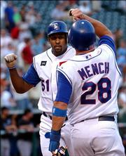 Texas' Richard Hidalgo is congratulated by teammate Kevin Mench after Hidalgo's home run against Kansas City. The Rangers beat the Royals, 4-3, Tuesday in Arlington, Texas.