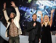 "American Idol" finalists Bo Bice, left, and Carrie Underwood, right, wave to the crowd from the stage with the show&squot;s host, Ryan Seacrest, after their final performance. Viewers voted Tuesday night on the performance and the results will be announced tonight.
