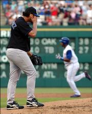 Royals starting pitcher Runelvys Hernandez, left, wipes his face as Texas' Richard Hidalgo rounds the bases. Hidalgo hit a two-run home run off Hernandez in the second inning.