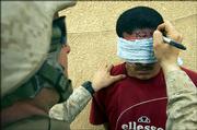 A U.S. Marine writes an identification number on the forehead of an Iraqi man detained during a search in Haditha, Iraq, 140 miles northwest of Baghdad. About 1,000 U.S. Marines, sailors and soldiers encircled Haditha, in the troubled Anbar province, on Wednesday, launching the second major operation in the vast western region in less than a month.
