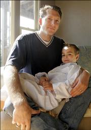 Jim Stickley, chief technology officer at TraceSecurity Inc., a
technology
security company based in Baton Rouge, La., holds his son Gannon, 5. When Stickley recently registered his son for karate classes, the form asked for his Social Security number and driver's license number.