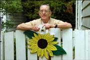 Master Gardener/ Jack Landgrebe rests on his side gate. Landgrebe's garden is part of the 2005 Douglas County Garden Tour, scheduled for Saturday and Sunday in Lawrence.
