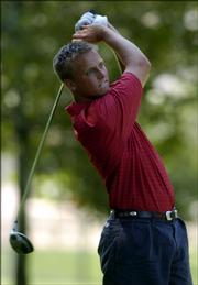 KU's Tyler Docking watches a tee shot during the Kansas Golf Assn. Four-Ball championship. The KU duo was tied in the final match when play was halted Sunday at Alvamar Golf Course.