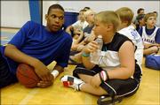 Kansas University sophomore-to-be C.J. Giles talks with Drew Henderson, of Kentucky, one of the campers at KU coach Bill Self's basketball camp. Giles was chatting Tuesday at Horejsi Center.