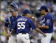 Kansas City pitching coach Guy Hansen, center, talks to pitcher D.J. Carrasco, right, and catcher John Buck during the first inning against Houston. Carrasco allowed just three runs in seven innings, but the Royals lost to the Astros, 6-2, Saturday night in Kansas City, Mo.