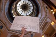 A GOP supporter waives a sign critical of the Kansas Supreme Court, which conservatives argue is overstepping its power and is in conflict with the constitution's separation of powers.