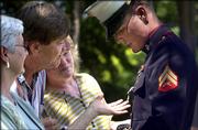 U.S. Marine Cpl. Jason Lilley's grandmother Vada Ambler, left, and his uncle and aunt Mike and Kathy Saindon check out Lilley's Silver Star following a ceremony in his honor at Veteran's Memorial Park on Friday in Wichita.